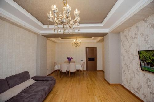 a living room with a couch and a chandelier at HappyHome in Masazır