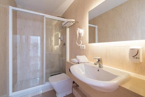 a bathroom with a sink and a shower and a toilet at Apartamentos Bossa Bay - MC Apartamentos Ibiza in Ibiza Town