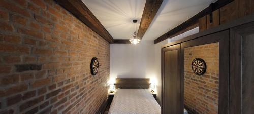 a room with a brick wall with a bed in it at Apartament loftowy in Świdnica