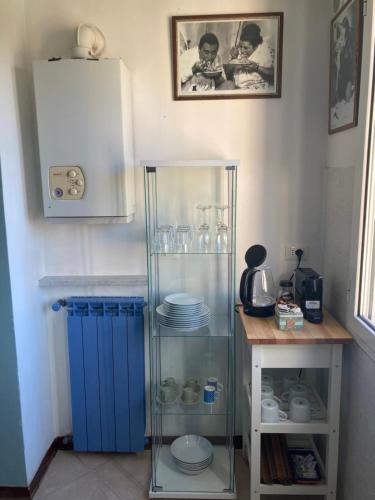 einen Glasschrank in einer Küche mit Tellern darin in der Unterkunft Nel blu dipinto di blu Apartment in Levanto