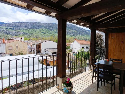 balcón con mesa, sillas y vistas en Hotel Alma Rosa en Navaluenga