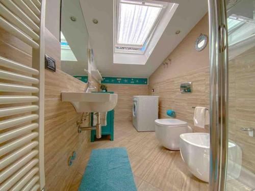 La salle de bains est pourvue d'un lavabo, de toilettes et d'une lucarne. dans l'établissement Terrazza Bay View, à Imperia