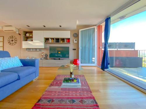 - un salon avec un canapé bleu et une table dans l'établissement Terrazza Bay View, à Imperia