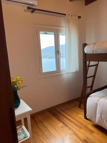 1 dormitorio con ventana y litera en Perdika's Nest, family friendly house by the sea, en Perdika
