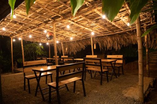 バガモンにあるTENT LIFEの屋根の下にテーブルと椅子が置かれた照明付きのレストラン