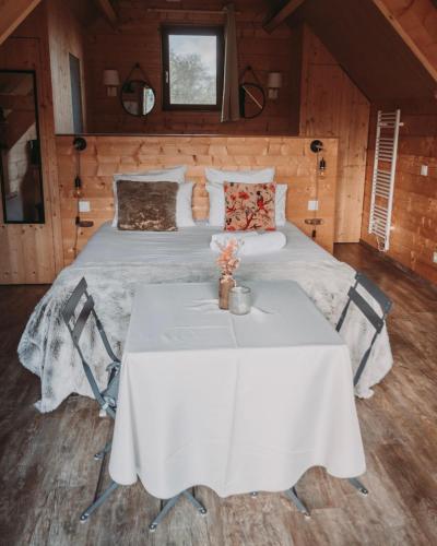a bedroom with a white bed and a table at Domaine de la Fauvriere in Sainte-Honorine-de-Ducy