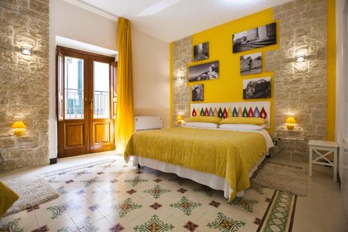 a bedroom with a bed and a yellow wall at Antico Borgo in Erice