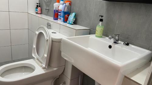 een witte badkamer met een toilet en een wastafel bij Sandakan Homestay Apartment Forest Cabin 森林小屋 2R2B in Sandakan