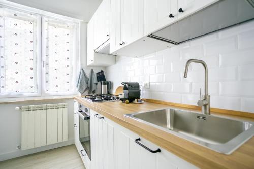 a white kitchen with a sink and a stove at La Casa di Lo near Vatican in Rome