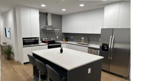 a kitchen with white cabinets and a white counter top at Enjoy our brand new home close to Hollywood in Hallandale Beach! in Hallandale Beach