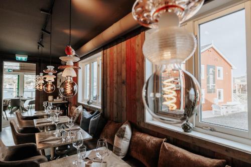 a restaurant with tables and chairs and a window at Hemmingodden Lodge in Ballstad