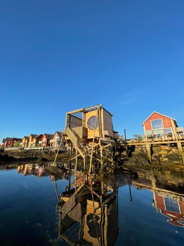 a row of houses on a dock next to the water at Hemmingodden Lodge in Ballstad