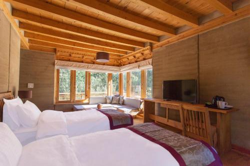 a large room with two beds and a television at Ladakh Eco Resort in Leh