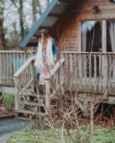 a woman standing on the porch of a house at Domaine de la Fauvriere in Sainte-Honorine-de-Ducy