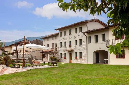 a large white building with a lawn in front of it at B&b La Casa di Elsa in Polcenigo