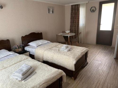 a hotel room with two beds and a table at Oldtown Apartments in Mtskheta