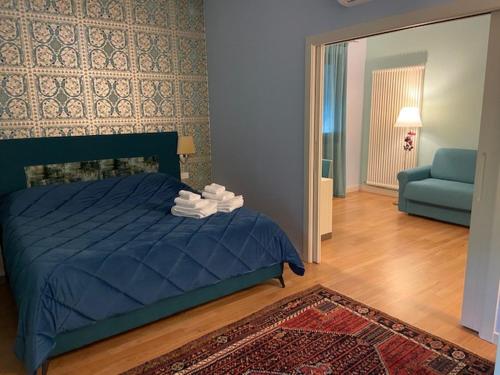 een slaapkamer met een blauw bed en een blauwe bank bij Ca' Masieri Hotel in Trissino