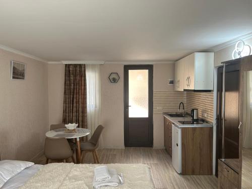 a hotel room with a bed and a table and a kitchen at Oldtown Apartments in Mtskheta