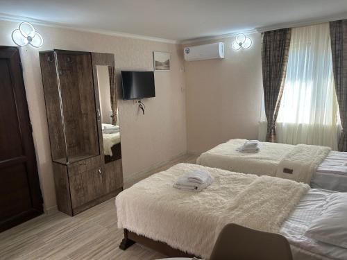 a hotel room with two beds and a television at Oldtown Apartments in Mtskheta