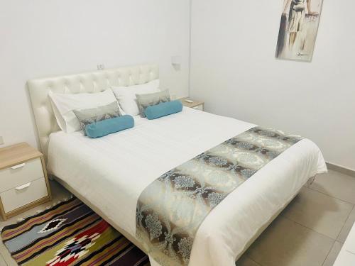 een slaapkamer met een groot wit bed met blauwe kussens bij Riverside Suite in Kalopanayiotis