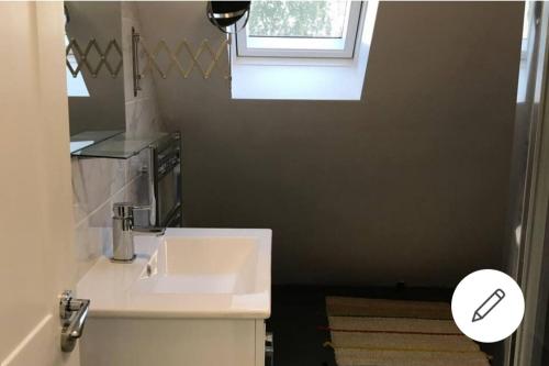 a bathroom with a white sink and a window at 1 bed apartment in West London in Heston