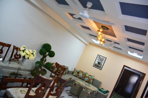 a dining room with a table and chairs and a ceiling at Khyber Guest House Swat in Saidu