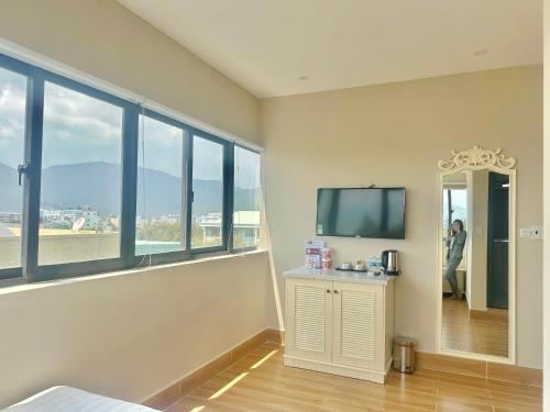 a room with a large window and a tv at Maya Hotel 2 in Con Dao