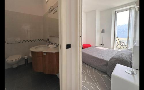 ein Schlafzimmer mit einem Bett, einem Waschbecken und einem WC in der Unterkunft Larius Apartment Carate Urio in Laglio
