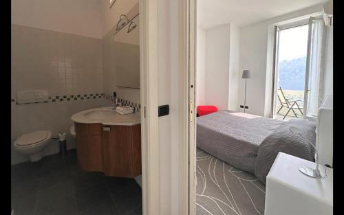 a bedroom with a bed and a sink and a toilet at Larius Apartment Carate Urio in Laglio