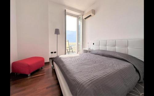 1 dormitorio con 1 cama grande y 1 silla roja en Larius Apartment Carate Urio en Laglio