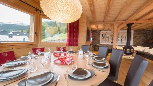 une salle à manger avec une table, des chaises et un lustre dans l'établissement Joyau des neiges - Chalet - BO Immobilier - Châtel - Multipass été 2025 offert, à Châtel