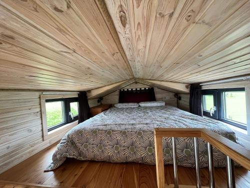 1 dormitorio en una cabaña de madera con 1 cama. en Tiny House des couriols, en Montmeyran