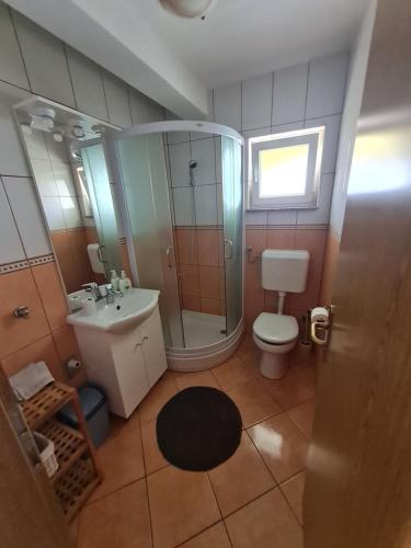 La salle de bains est pourvue d'une douche, de toilettes et d'un lavabo. dans l'établissement Apartments Bosnjak, à Šibenik