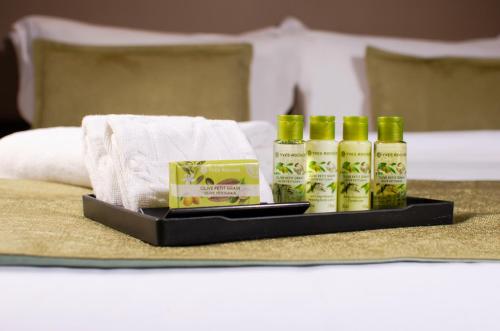 a tray with four bottles of hair products on a bed at The Marison Hotel in Legazpi