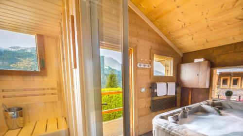 a bedroom with a large window and a bed in a room at Joyau des neiges - Chalet - BO Immobilier - remises sur les forfaits de skis Châtel ou Portes du soleil in Châtel