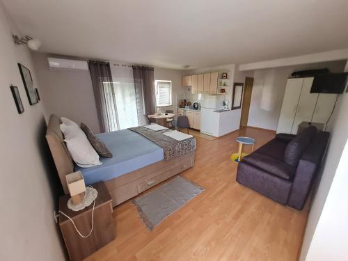 Cet appartement comprend une chambre avec un lit et un canapé ainsi qu'une cuisine. dans l'établissement Apartments Bosnjak, à Šibenik