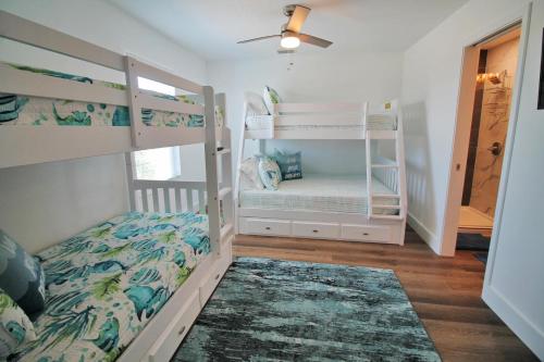 1 Schlafzimmer mit 2 Etagenbetten und einem Deckenventilator in der Unterkunft Shore Beats Work in Mexico Beach