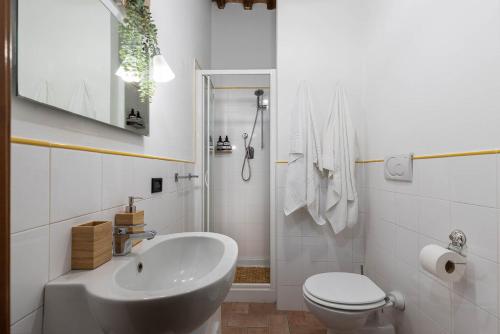 Baño blanco con lavabo y aseo en Il Chiostro, en Siena