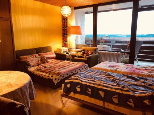 a room with two beds and a couch and a living room at Apartment mit toller Aussicht in Bad Liebenzell