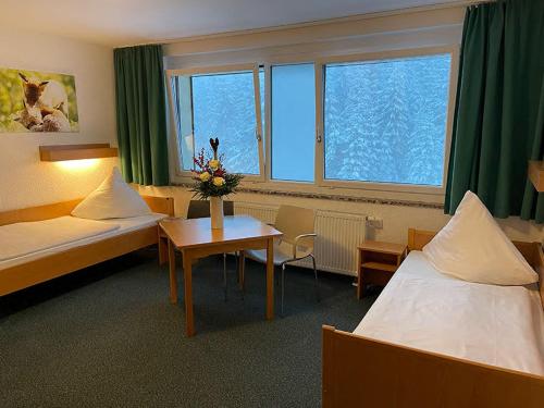 um quarto de hotel com duas camas e uma mesa com flores em A&S Ferienzentrum Oberhof em Oberhof