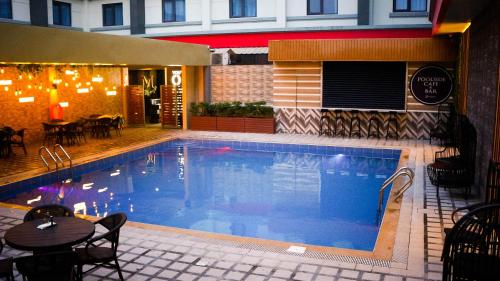 a swimming pool with a table and a restaurant at The Marison Hotel in Legazpi