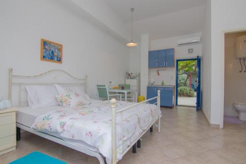 - une chambre avec un grand lit blanc orné de fleurs dans l'établissement Apartments Dunato Nedeljko, à Šilo