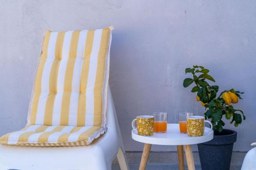 a chair with two cups on a table with at Studio Apartman LEMON in Dubrovnik