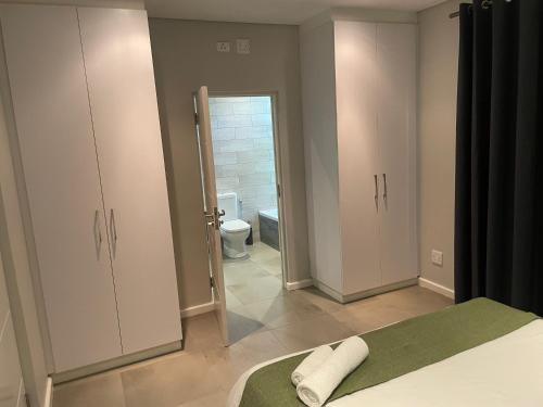a bedroom with a bed and a bathroom with a toilet at The Executive - Exclusive Self-Catering Apartments - Ezulwini in Ezulwini