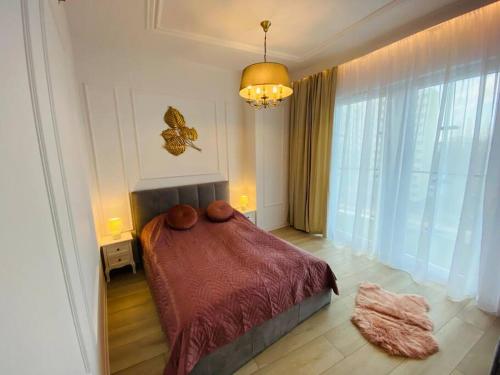 a bedroom with a bed and a large window at Gustowny apartament na Woli in Warsaw
