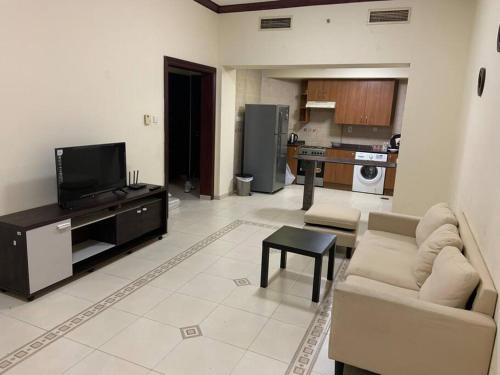 - un salon avec un canapé et une télévision dans l'établissement Sahara private apartment, à Dubaï