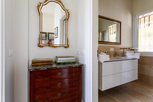 een badkamer met een houten dressoir en een spiegel bij Sea side apartment between Nice and Monaco - 2 in Villefranche-sur-Mer