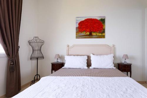 Un dormitorio con una cama blanca y un árbol rojo en Sea side apartment between Nice and Monaco - 2 en Villefranche-sur-Mer