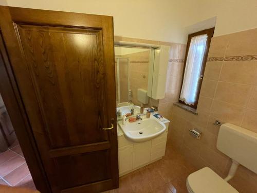 La salle de bains est pourvue d'un lavabo, de toilettes et d'un miroir. dans l'établissement B&B San Biagio, à Marola