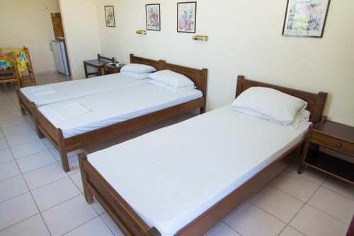 two twin beds in a room with at Fokion Studios in Lakíthra